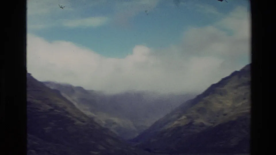 1982 New Zealand 8mm frame looking into a mountain valley as low cloud hangs over distant ridges.
