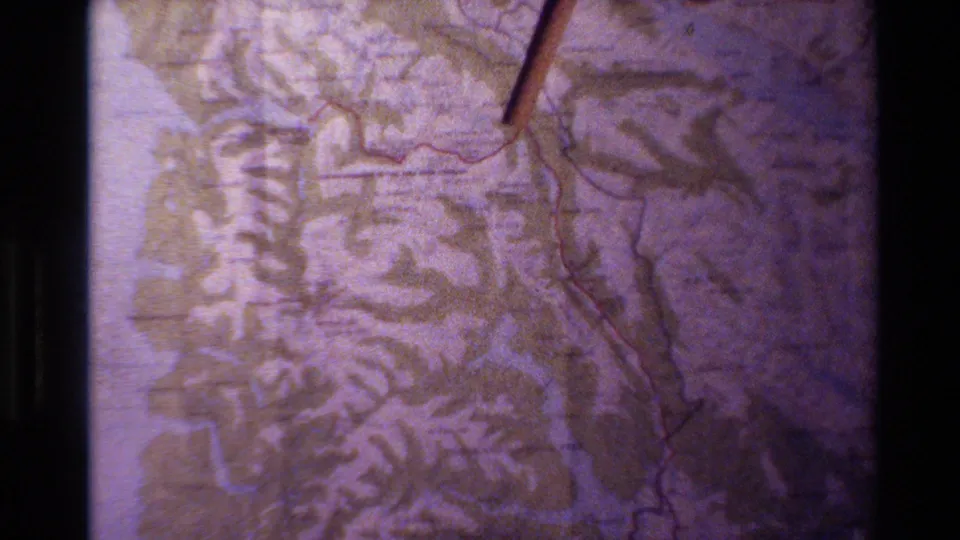 The final 1982 New Zealand frame shows a pointer beside a red line on a soft, purple-tinted topographic map.