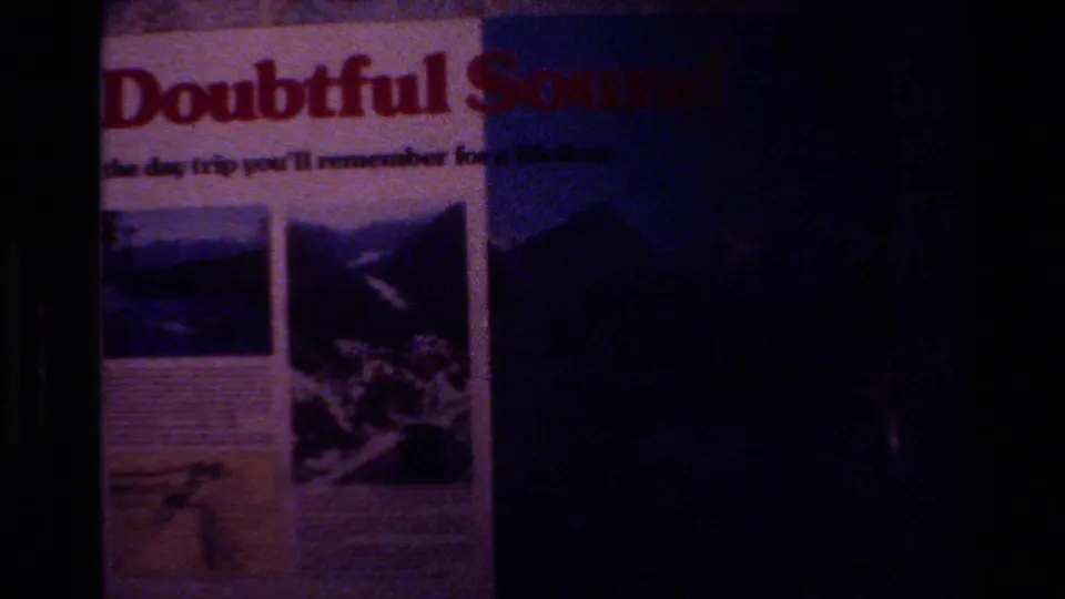 1982 New Zealand 8mm frame showing a partially underexposed Doubtful Sound travel poster with scenic photographs.