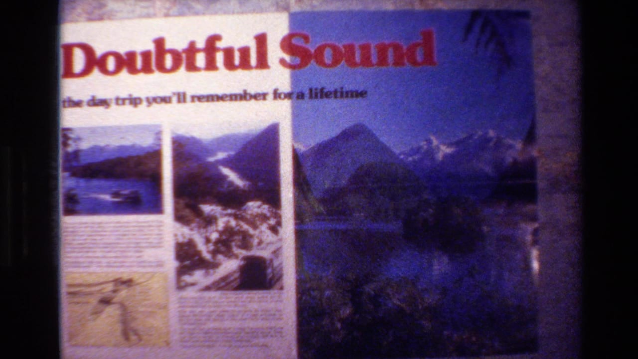 Doubtful Sound sign beside a blue-toned projected scenic view.