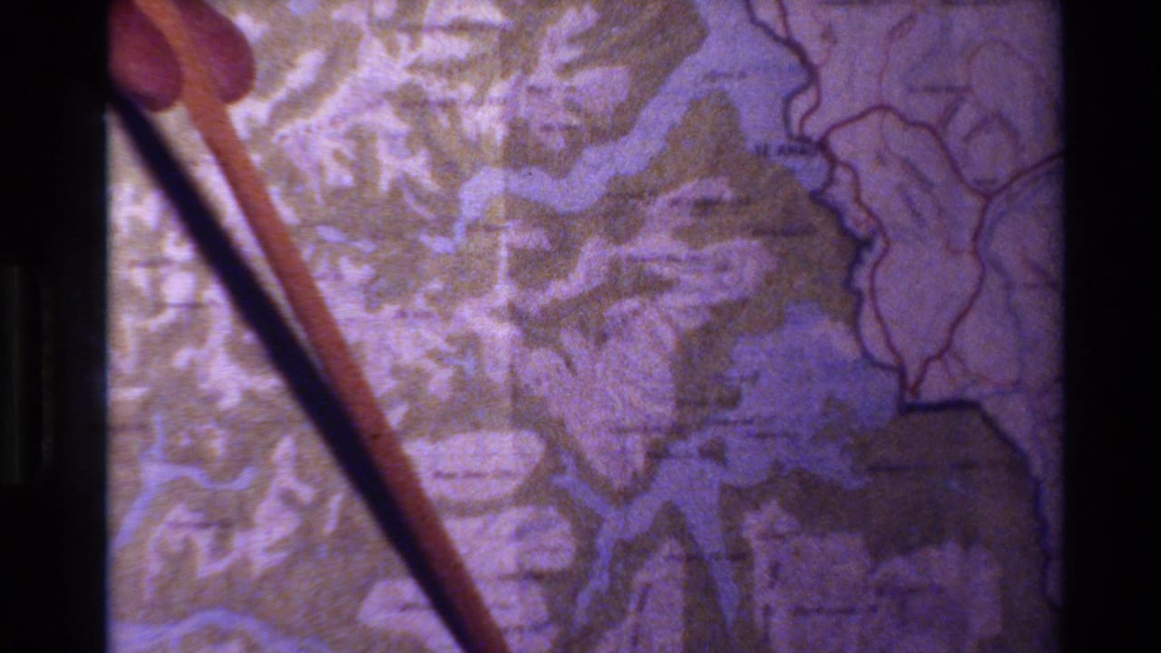 Pointer stick held over a topographic map with waterways and contour markings.
