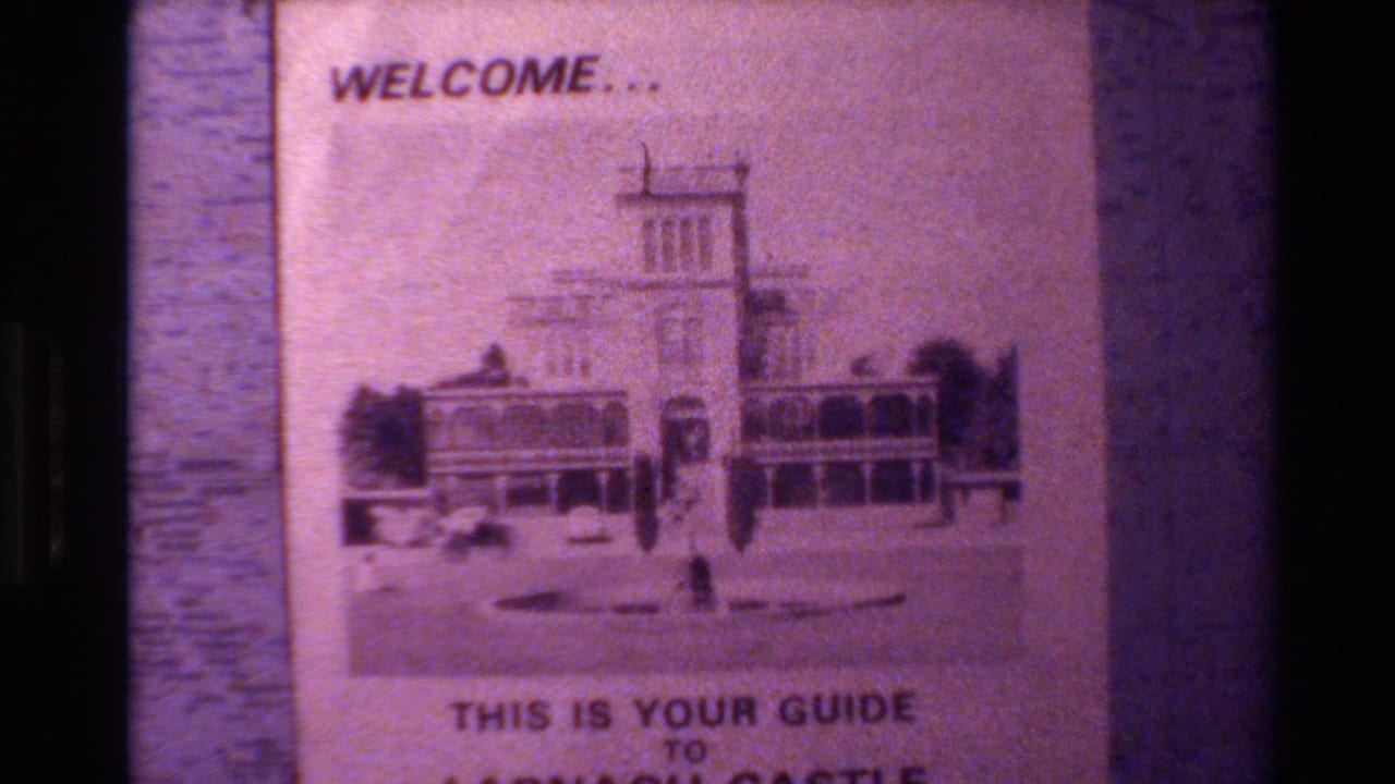 1982 New Zealand home-movie frame showing a Larnach Castle guide cover with welcome text and a printed castle illustration.