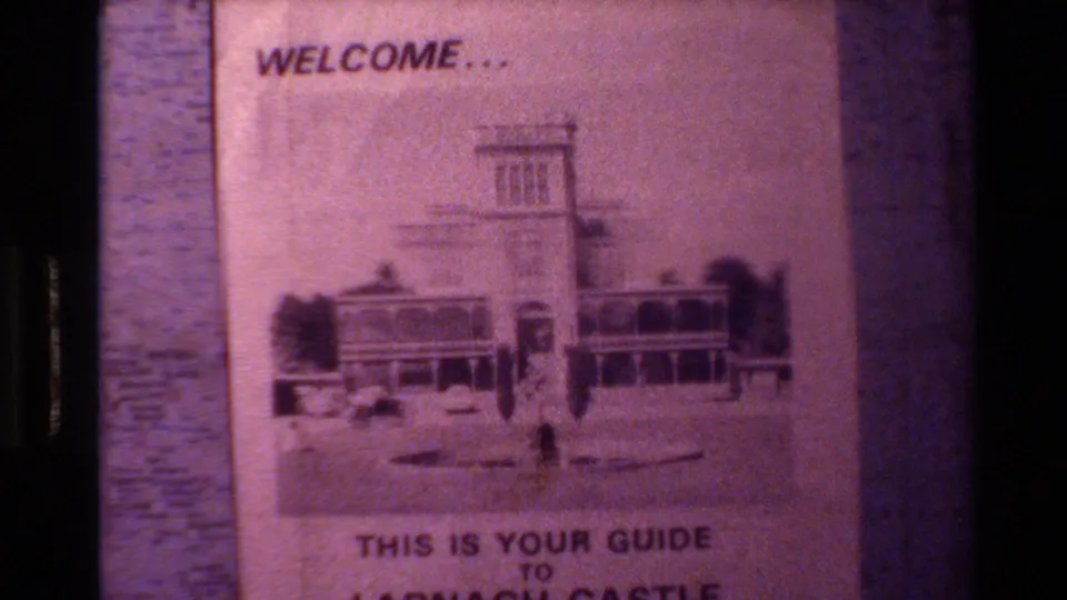 Visitor-shot close-up of the Larnach Castle pamphlet, with the printed building and guide text visible through soft Super 8 grain.