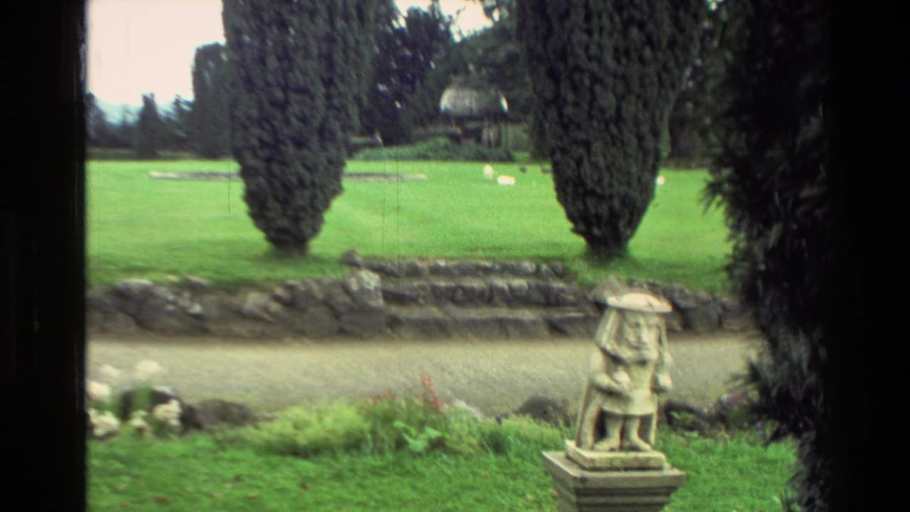 Stone garden statue on a pedestal near rock steps and cypress trees.