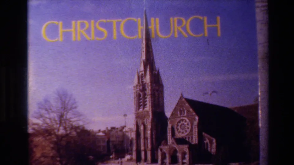 1982 Christchurch title-card frame showing a church facade and tall steeple under yellow lettering, with visible 8mm grain and color fading.