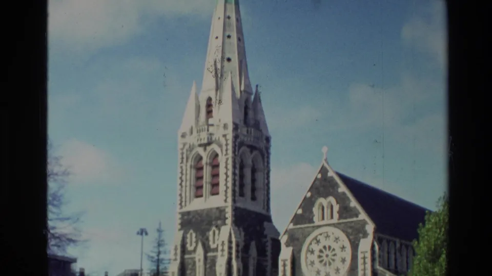 The final frame looks up at the church spire and rose window, with trees and blue sky framing the 1982 New Zealand landmark view.