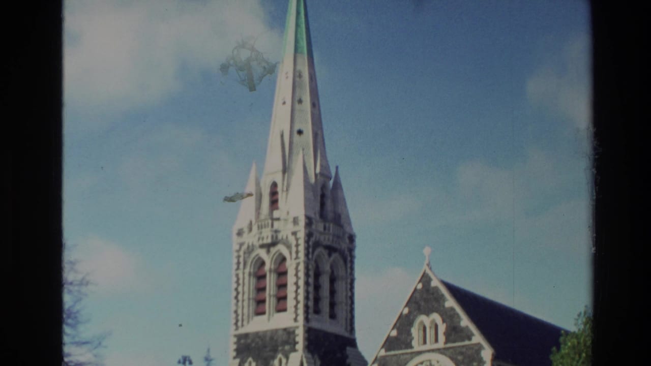 1982 New Zealand 8mm frame showing a Gothic Revival cathedral spire, tower openings and roofline under a bright sky.