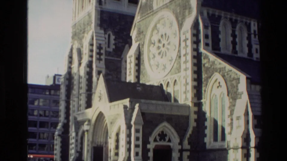 1982 New Zealand 8mm frame showing the cathedral facade, circular rose window, arched doorway and adjacent tower.