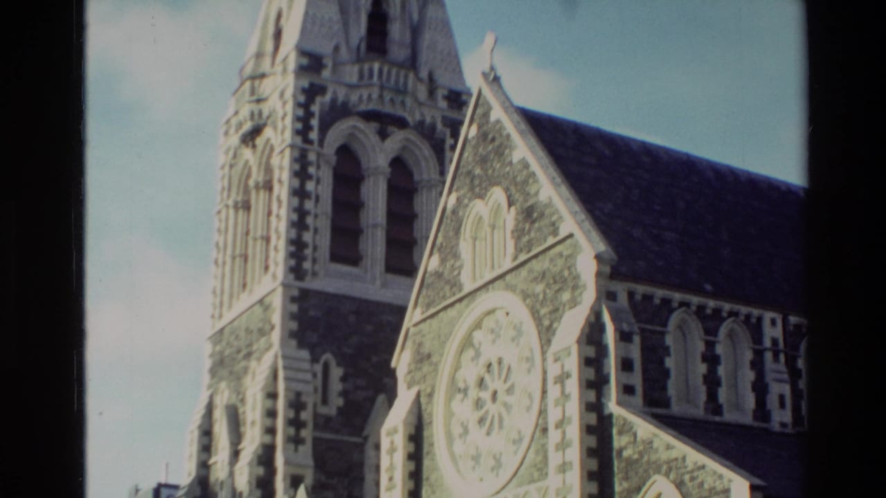 1982 New Zealand 8mm frame showing an exterior stone church tower, steep gable and Gothic-style arched details.