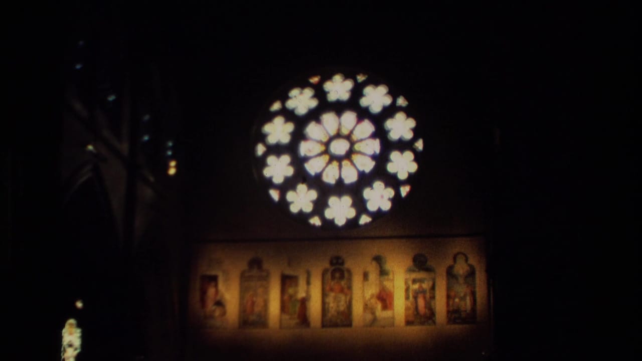 Dark church interior with glowing circular rose window above religious artwork panels.