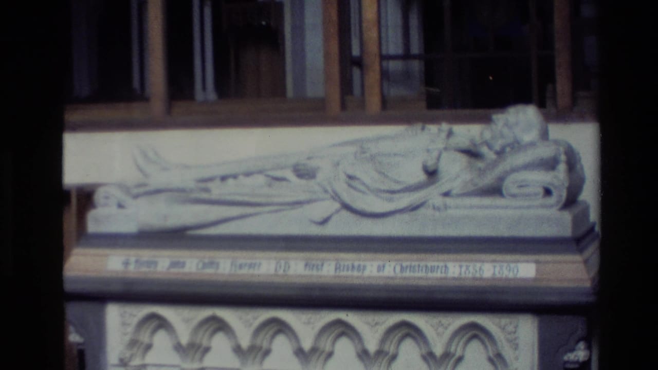 1982 New Zealand 8mm frame showing a close view of a carved reclining bishop effigy and inscription panel inside a church.