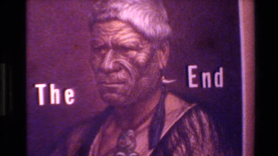 1982 8mm closing title card showing a portrait of an older man beside the words The End in purple-toned light.