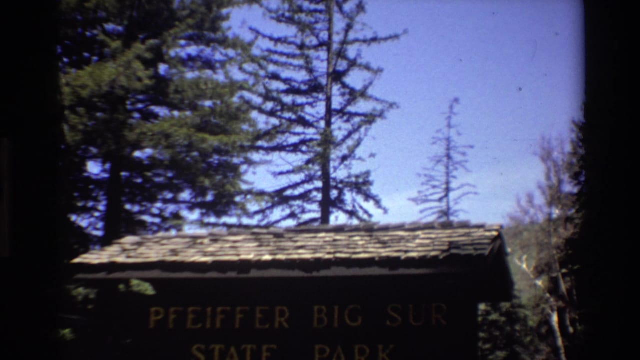Wooden Pfeiffer Big Sur State Park sign under a shingled roof.