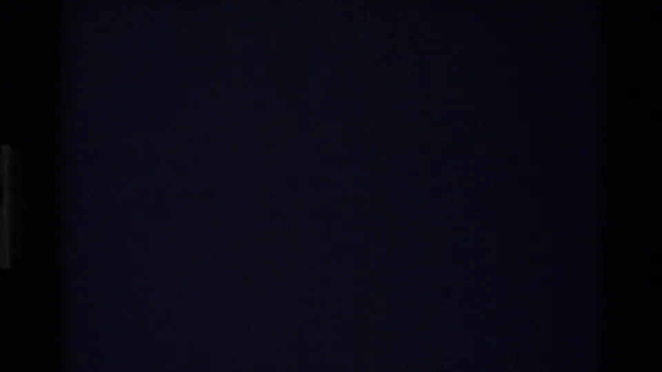 Very dark 8mm transition frame from the 1980 Big Sur clip, with no clear subject visible.