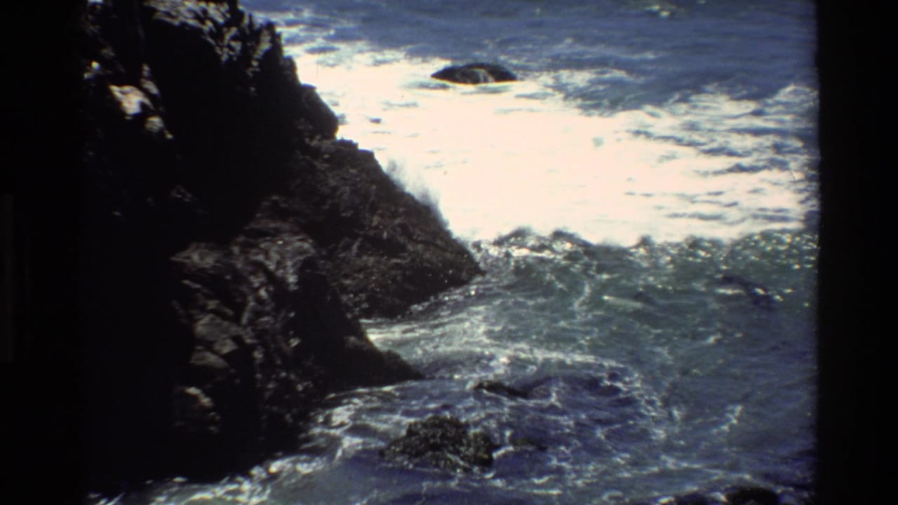 Pacific coastline rocky shore, circa 1980, likely Big Sur area — 8mm footage of waves churning around a dark rock formation.