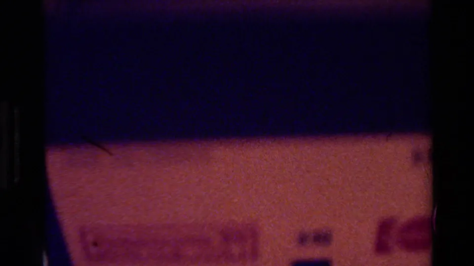 Underexposed end frame from the 8mm scan, showing dark purple and reddish color bands rather than a clear cactus view.
