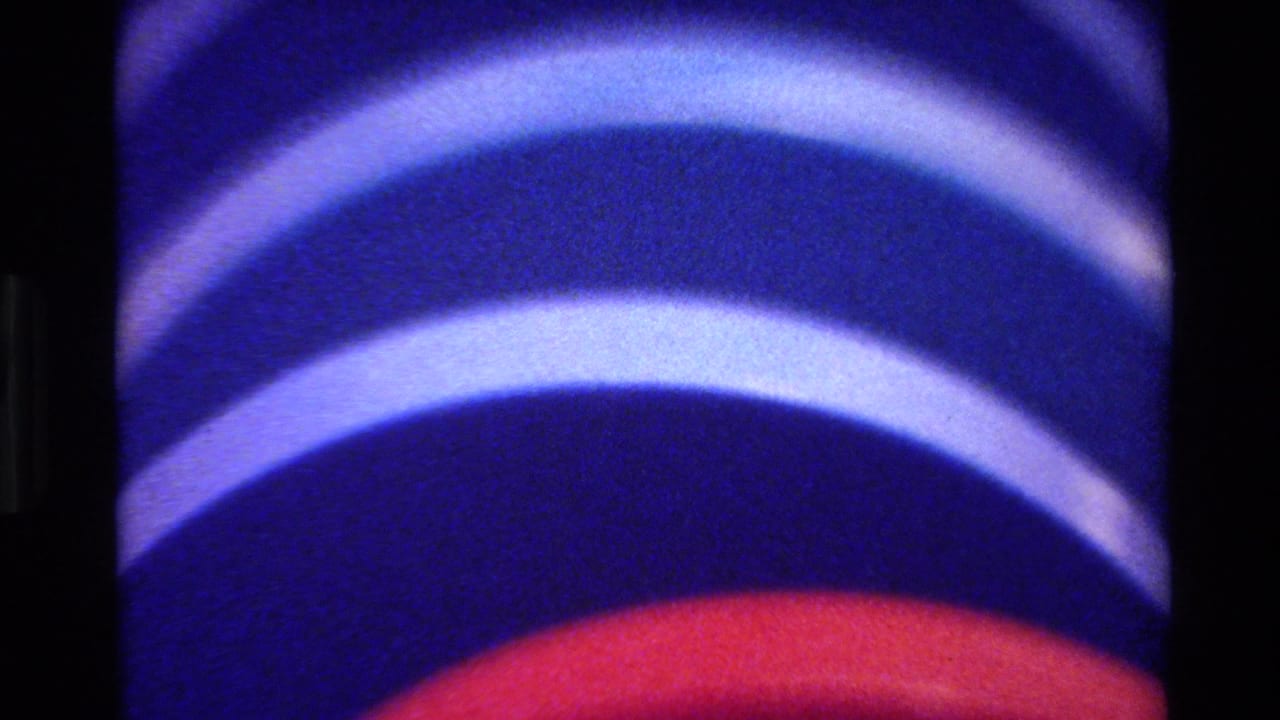 Blue bands dominate a rounded form, with a red curve near the lower edge.