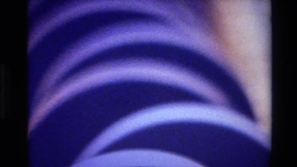 1980 Big Sur 8mm frame showing multiple blue concentric ring bands with warm highlights and visible film grain.