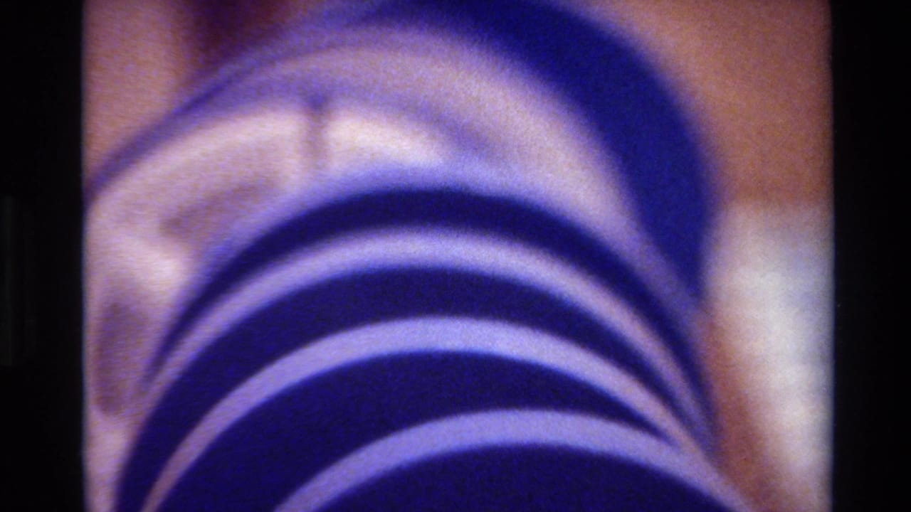 Purple ribbed hose or tube viewed close up, with pale material visible near the upper edge.