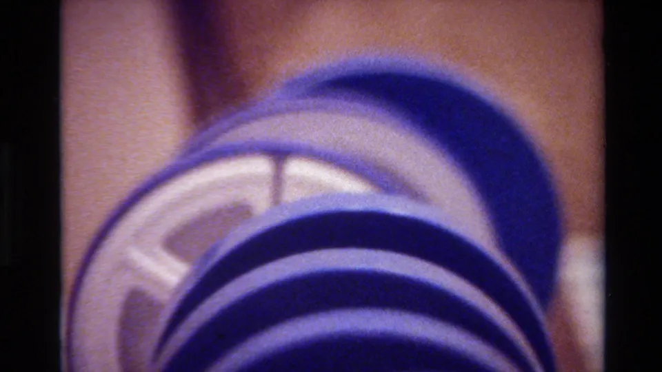 1980 Big Sur home-movie frame showing a purple segmented hose or tube partly disconnected, exposing a white inner core.