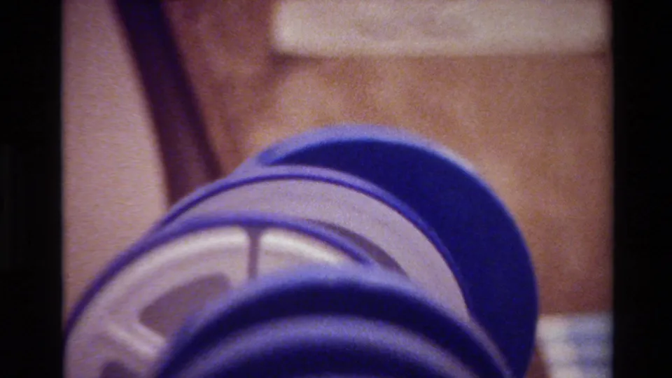 1980 Big Sur 8mm frame of a purple ribbed hose or tube angled across the shot, with a pale inner section exposed.