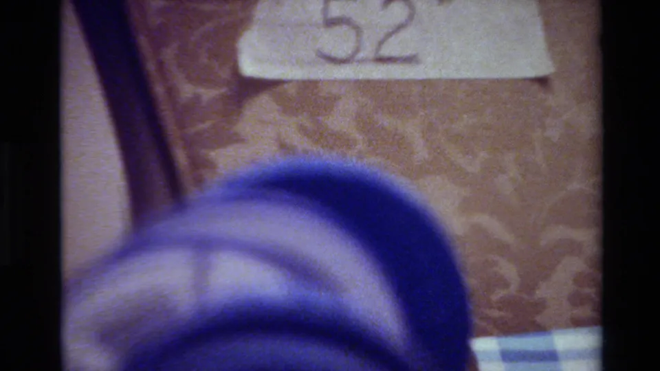 Final frame shows the 52 inch tape label on patterned upholstery with a larger blue blurred object crossing the lower foreground.