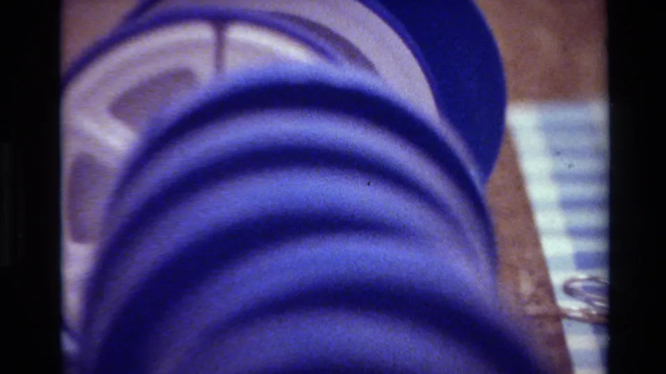 Blue 8mm reel fills most of the frame, with brown storage material and a pale striped area at the side.