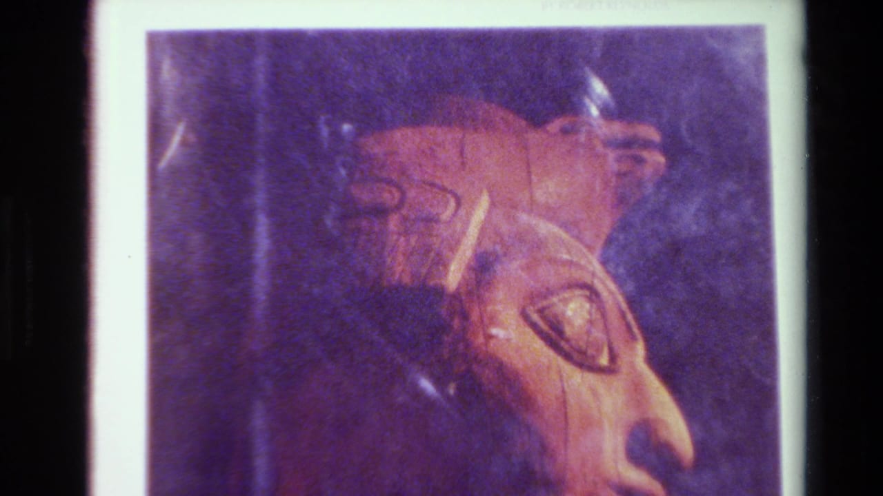 Brown carved profile with eye and nose on a printed page bordered in white.