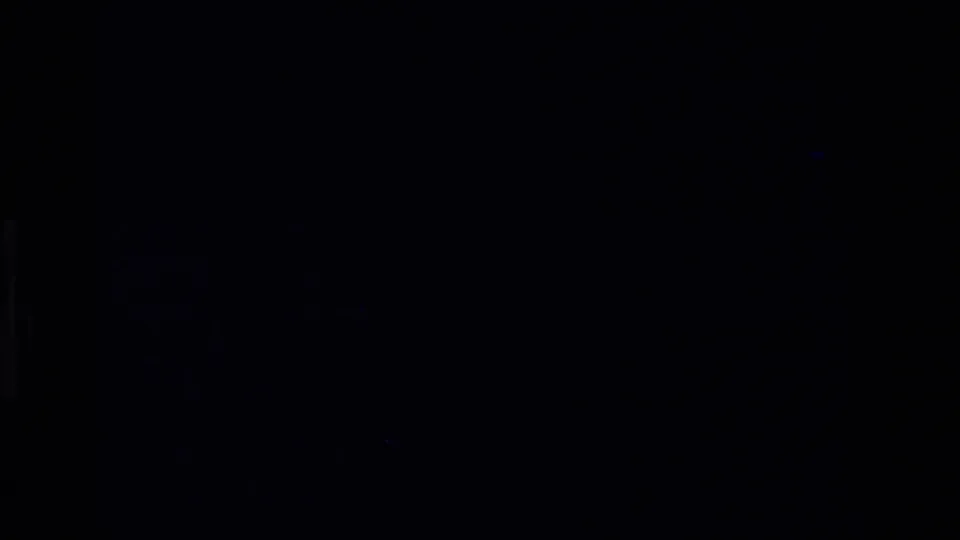 A very dark 8mm frame with faint grain and slight edge detail, likely part of a brief exposure or transition in the home movie.