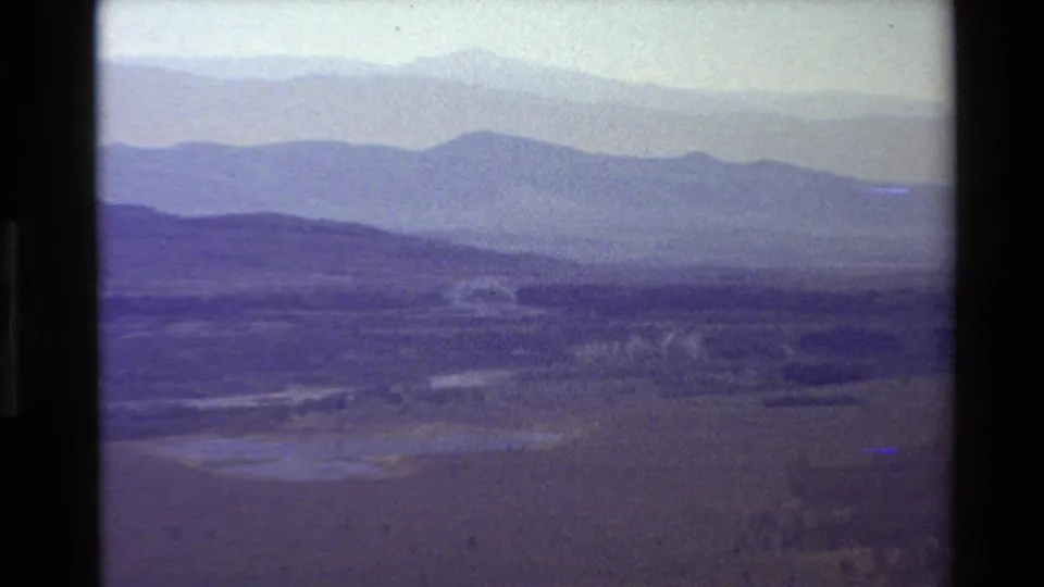 1980 Grand Teton-area home-movie view of hazy mountain ridges receding above a wide valley floor.