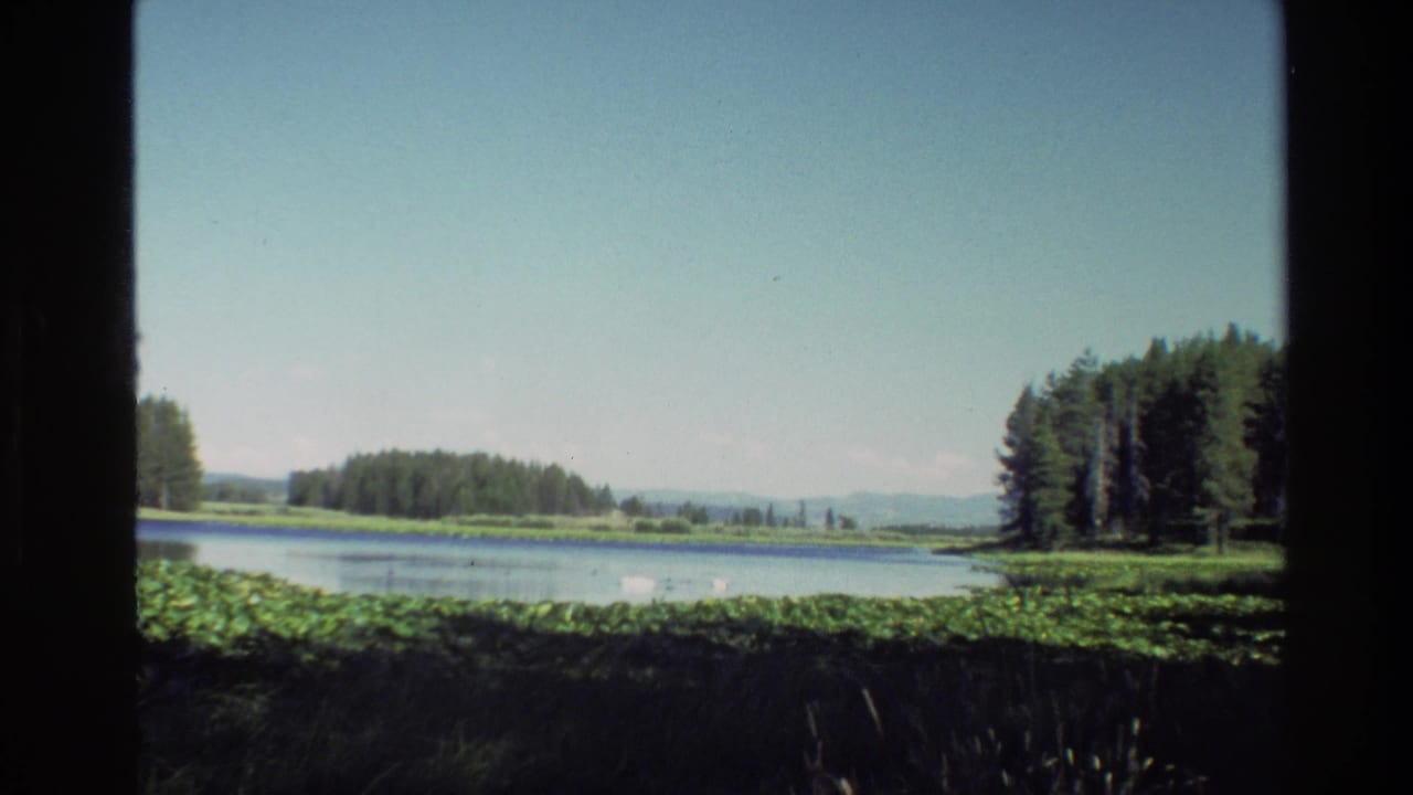 Lake landscape with conifer trees, low mountains, bright sky, and window-frame borders.