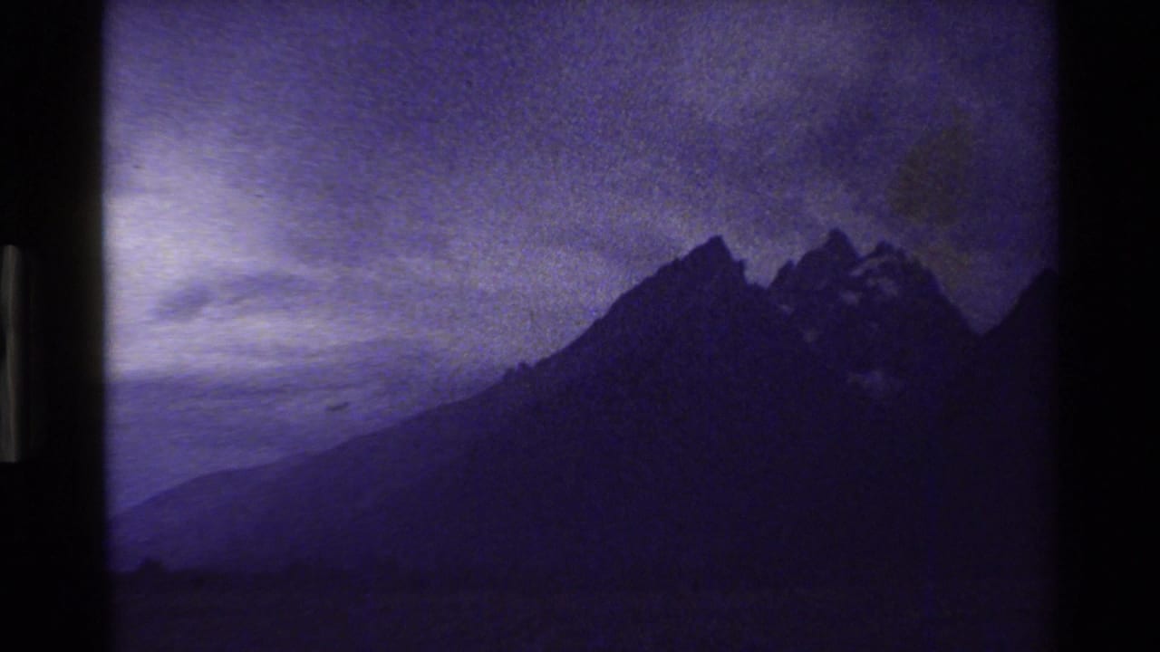 Jagged mountain silhouette under a cloudy purple sky.