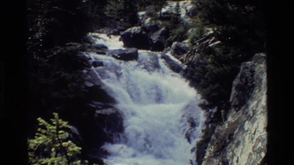 Wide 8mm view of a mountain stream dropping through rocks and forest in the Grand Teton, Wyoming area.