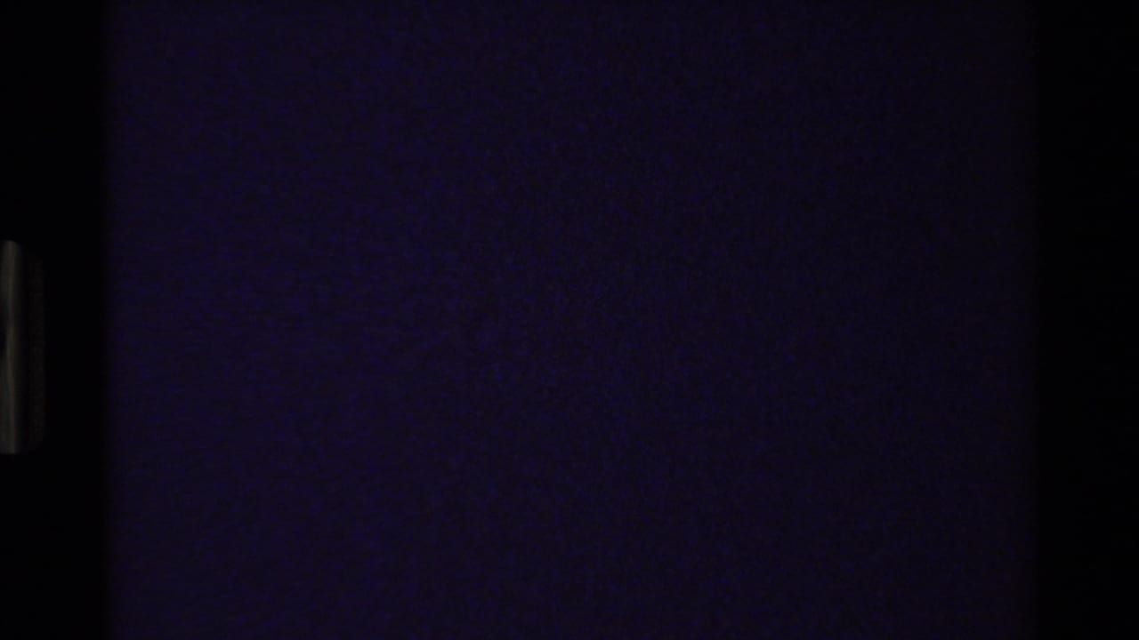 Very dark purple-tinted frame with little visible landscape detail.