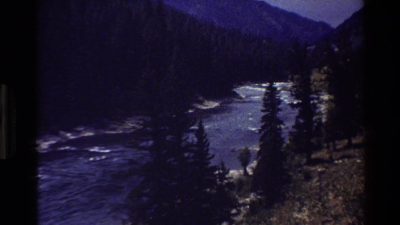 Grand Teton, Wyoming 8mm frame showing a mountain river corridor with rapids, forested slopes, and dark film edges.