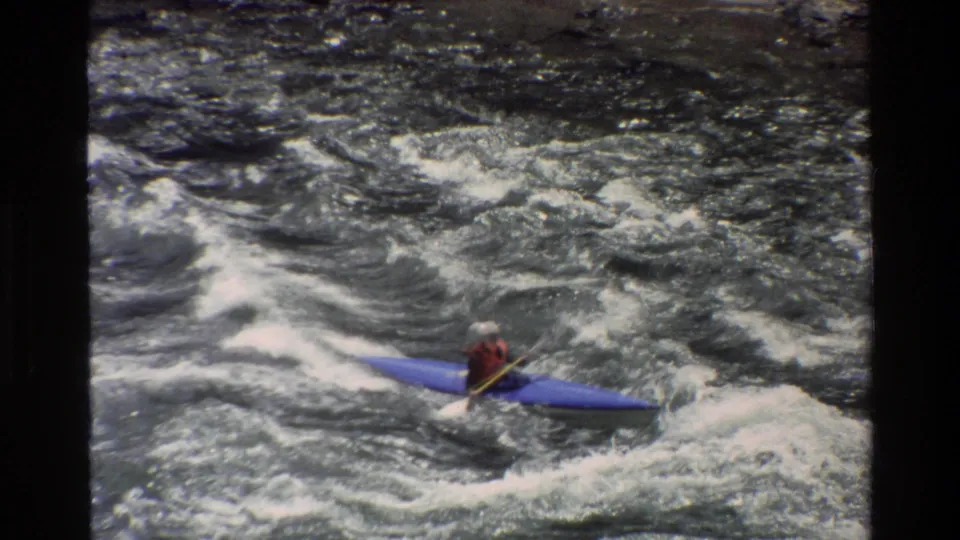 Grand Teton, Wyoming 1980 frame showing the kayaker continuing through fast whitewater, with film grain and gate edges visible.