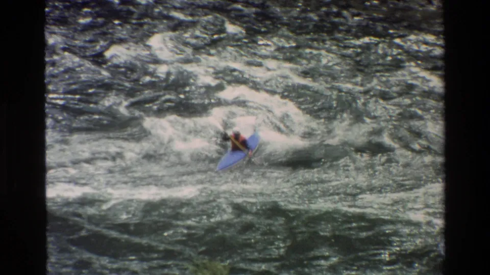 The blue kayak angles through foamy Grand Teton rapids as the paddler braces with a paddle in the final frame.