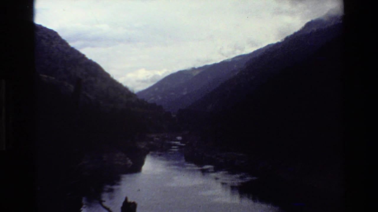 Circa-1980 8mm view of a mountain valley and winding river, likely part of a western U.S. travel sequence.