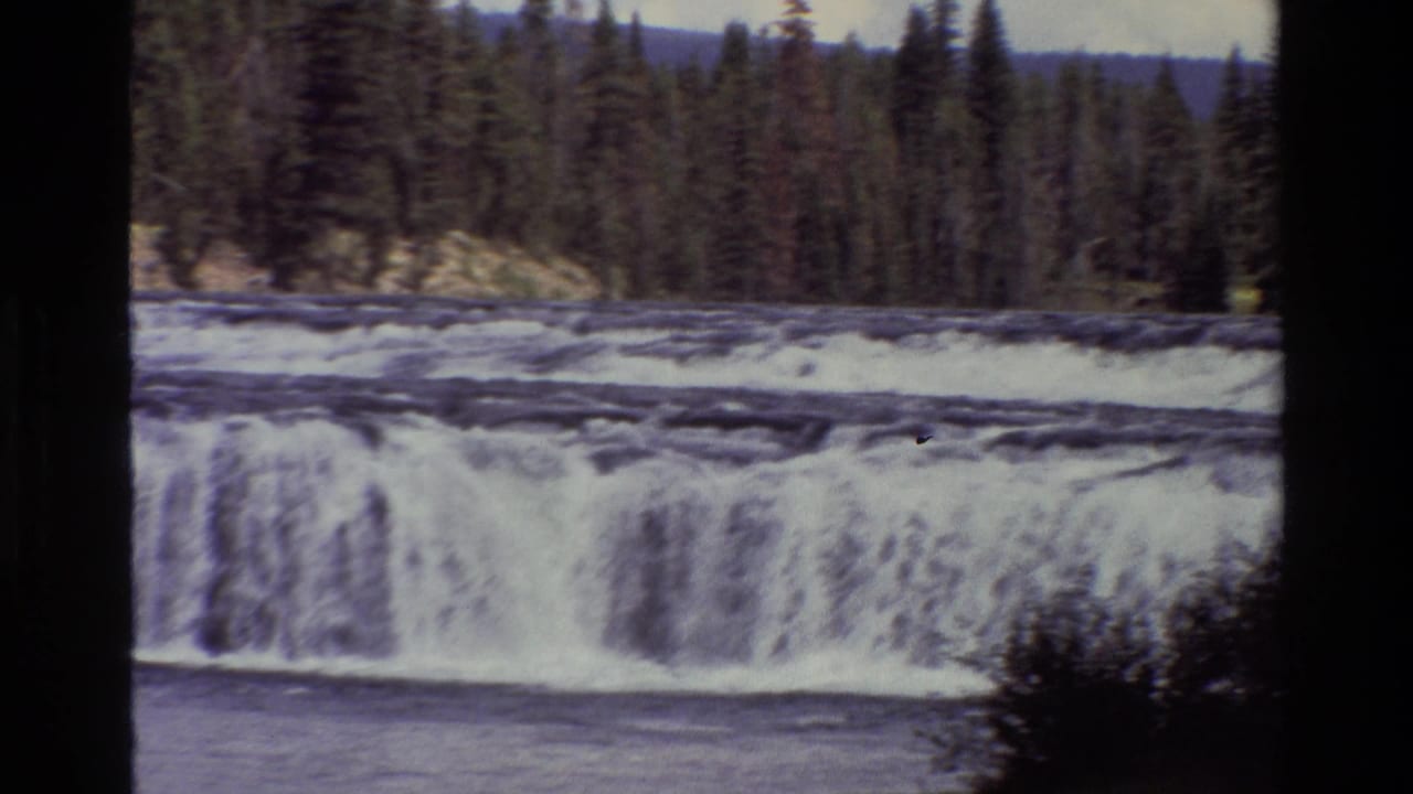 1980 8mm Grand Teton travel footage showing a broad waterfall and white water below a dense evergreen forest.
