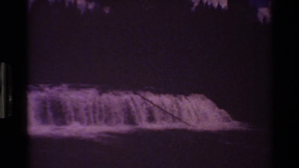 Underexposed 1980 8mm frame from the Grand Teton, Wyoming clip showing white water crossing a low fall.