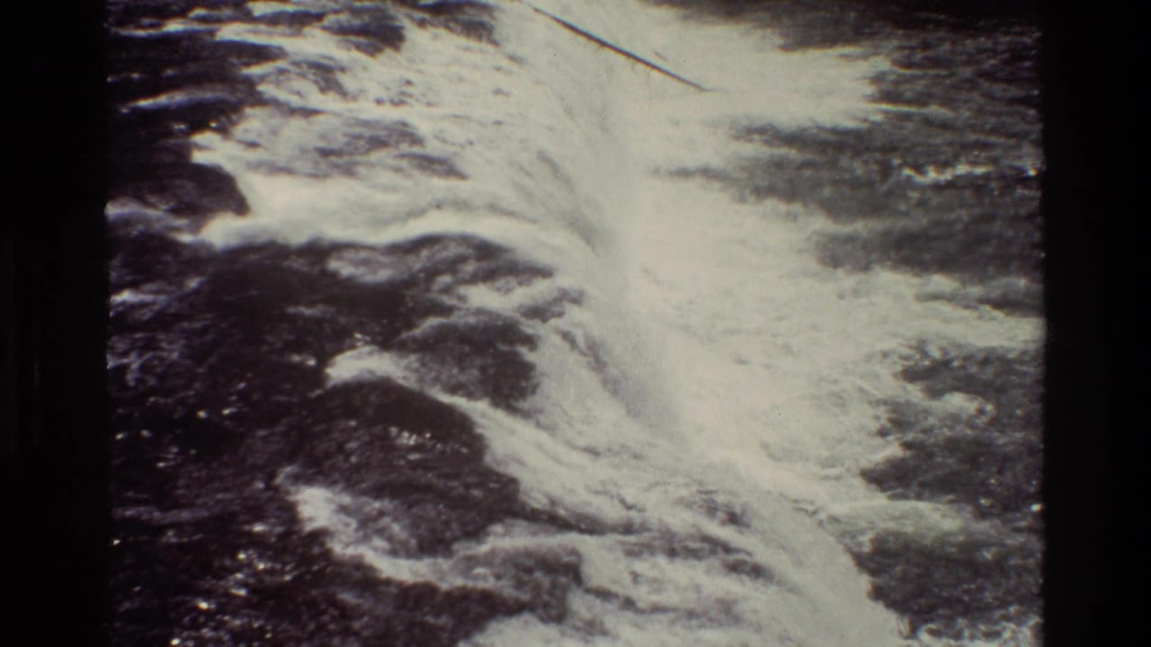 Foamy waterfall flow spreading across dark rock surfaces.