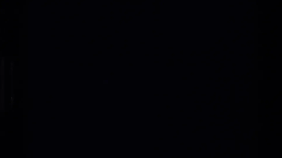 Underexposed 8mm frame from the Beale AFB sequence, with only faint structural shapes visible in heavy shadow.