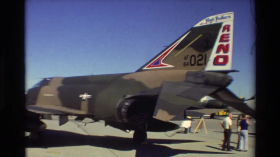Camouflaged F-4 Phantom II tail with RENO and AF 021 markings appears beside visitors at Beale AFB in 1981.