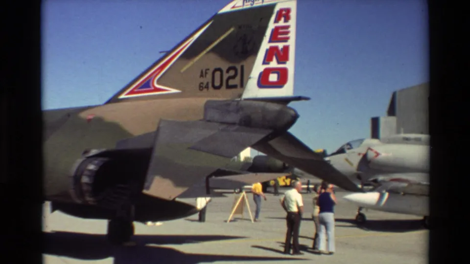 1981 Beale AFB home-movie frame showing the rear of an F-4 Phantom II with RENO tail markings and civilians nearby.