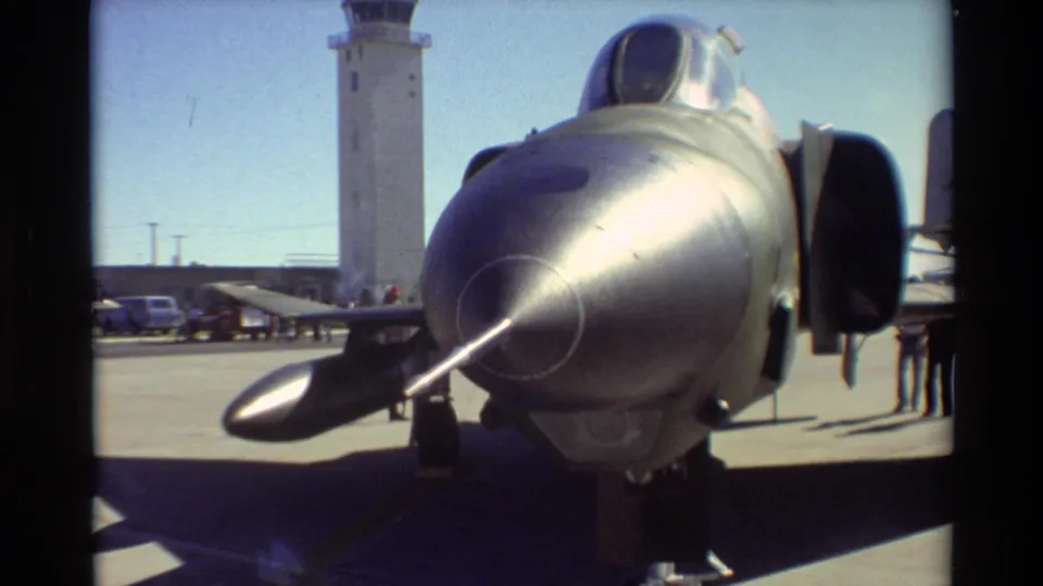 Close 1981 Beale AFB home-movie view of the F-4 Phantom II nose, canopy, intake, and background tower.