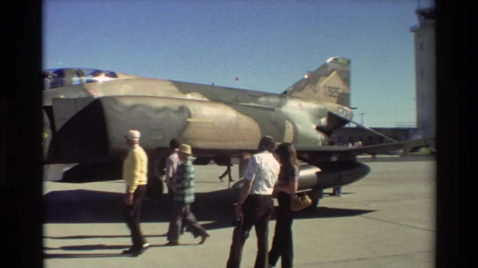 A small group of adults walks beside the rear section of the F-4 Phantom II at Beale AFB in 1981.