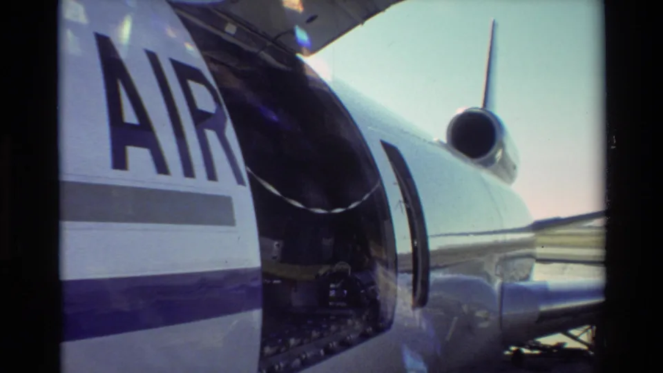 Close 8mm view of the aircraft side at Beale AFB, showing partial AIR lettering and an open cargo door area.