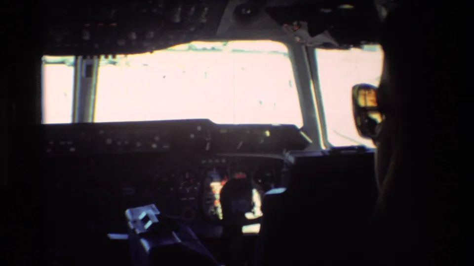Inside the aircraft cockpit at Beale AFB, the dark instrument panel is silhouetted against bright forward windows.