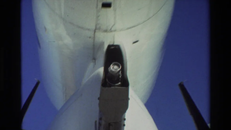 Close 8mm frame from Beale AFB showing the C-141 rear underside, tail structure, high-mounted wing edges, and cargo-door area detail.