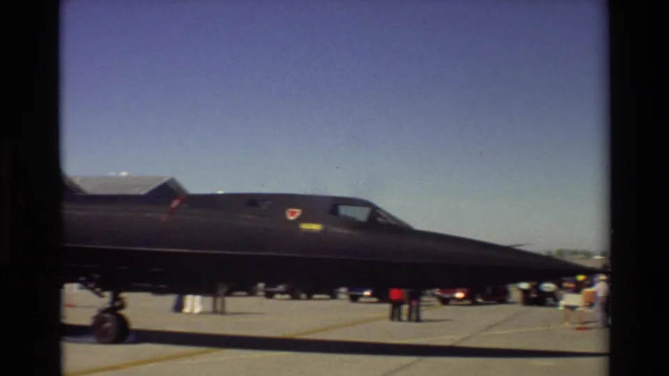 1981 Beale AFB frame showing the SR-71 Blackbird in side profile, with sharp nose, cockpit area, landing gear, and visitors near the display.